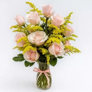Arranjo com rosas cor-de-rosa e folhagens no vaso de vidro